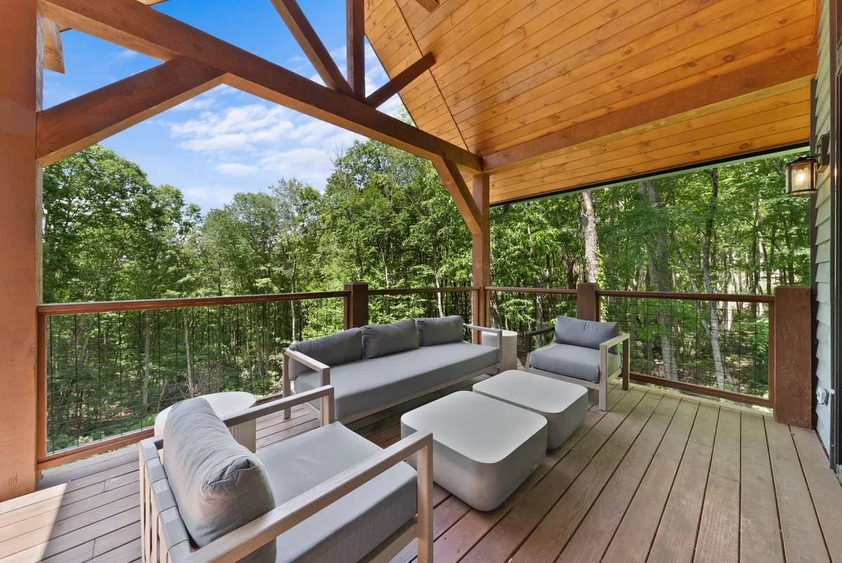 The spacious wooden deck overlooks lush greenery, offering comfortable seating and unobstructed views of the natural setting. This tranquil spot is ideal for relaxing after a walk or sharing quiet moments with your pet while enjoying the sights and sounds of the outdoors.
