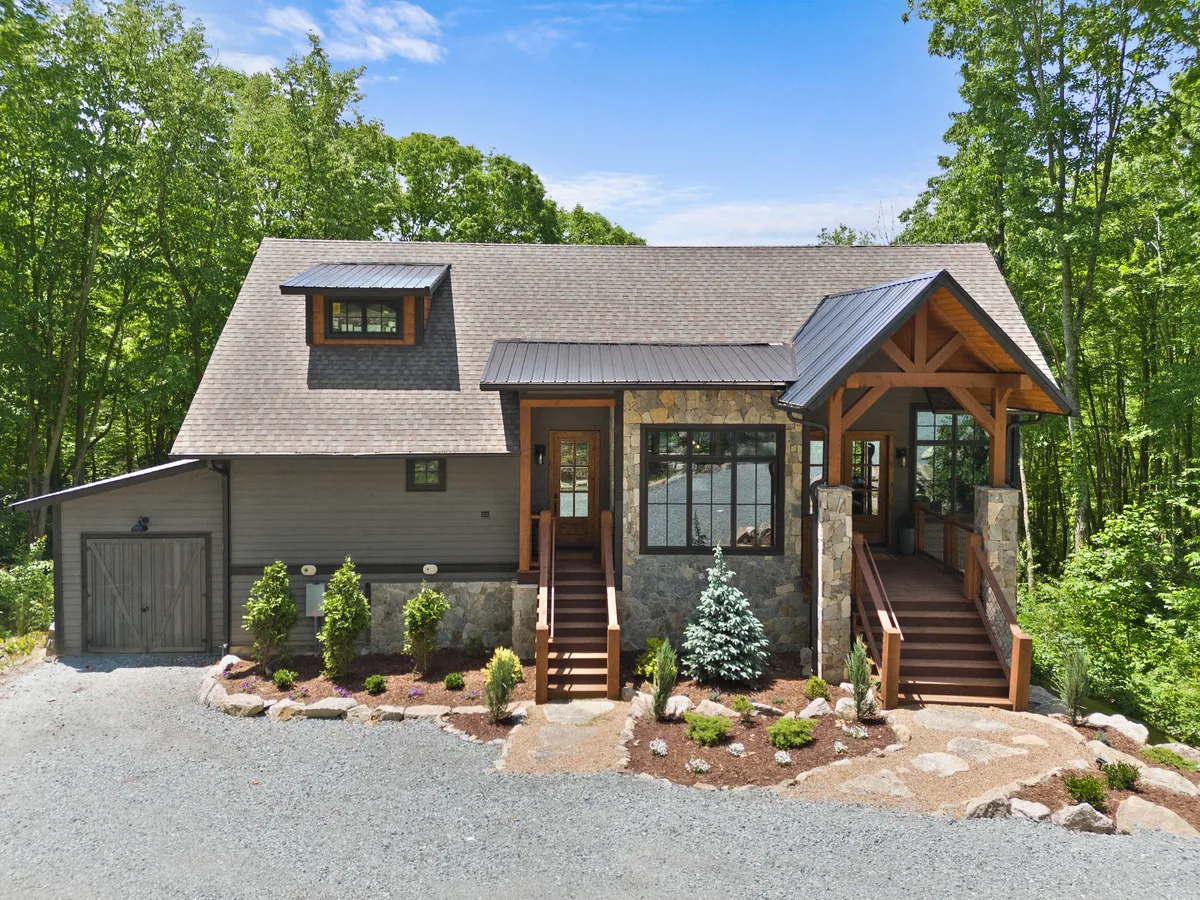 This image features the front porch of Boulder Springs Lodge, accented with stone and surrounded by beautifully landscaped gardens. The inviting porch offers a cozy spot for morning coffee while taking in nature. The surrounding greenery and pathway suggest easy access to nature walks and outdoor adventures.